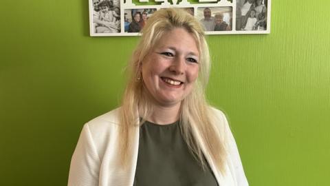 Vicki Chadwick posing in front of a lime green wall