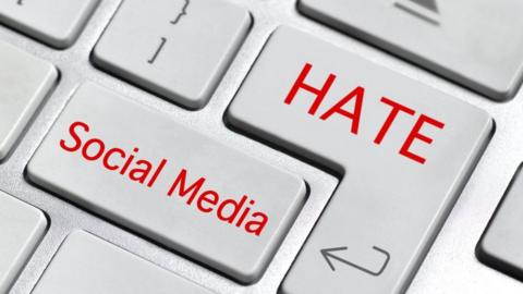 Composite image of a keyboard with words hate and social media superimposed