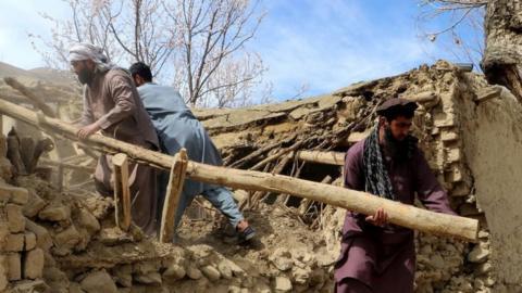 Residents clear debris from a damaged a house at Sooch village in Jurm district of Badakhshan Province on March 22, 2023, following an overnight earthquake