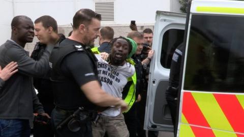 Adam Jameh being taken away from police