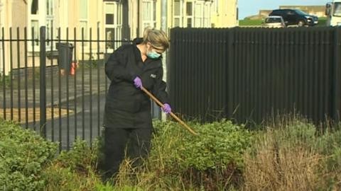 police officer searches bushes