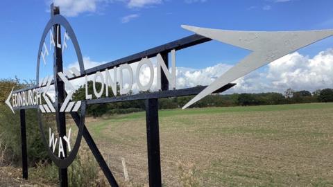 Image of sign marking halfway between London and Edinburgh