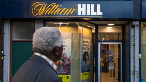 Man looking at William Hill shopfront