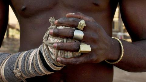 A close up of a Dambe fighter's hands, detailing his spear and shield