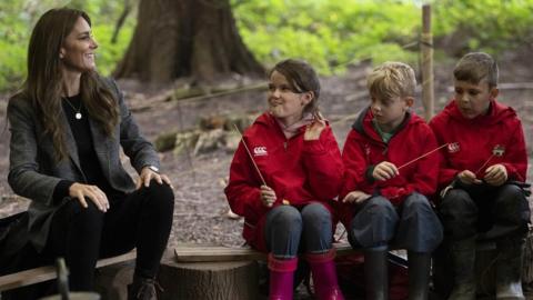 Catherine with youngsters as they cooked on a camp fire