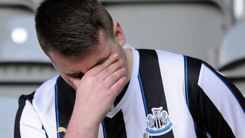 A Newcastle fan looks dejected