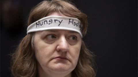 A woman wearing a "hungry hostage" headband protests on Capitol Hill