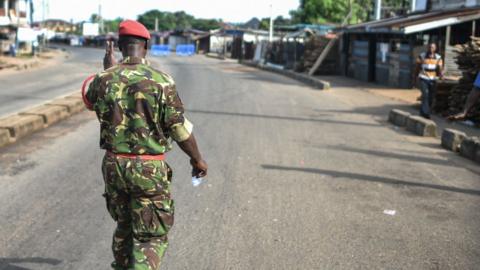 A soldier with the Sierra Leonean military police walks the deserted streets of Freetown after attack