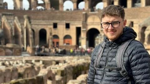 Kieran Stoneman stood at the Colosseum in Rome, Italy