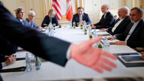 A security person asks reporters to leave a room where U.S. Secretary of State John Kerry, left, meets with Iranian Foreign Minister Mohammad Javad Zarif, second from right, at a hotel in Vienna, Austria, Wednesday, July 1, 2015. (Carlos Barria /Pool via AP)