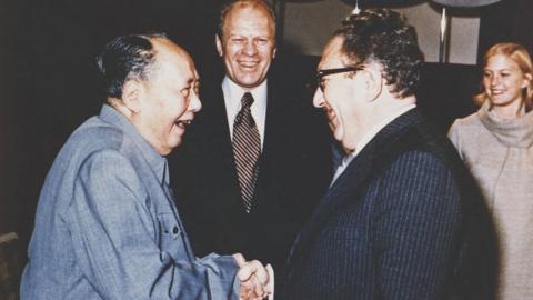 U.S. President Gerald Ford and his daughter Susan watch as U.S. Secretary of State Henry Kissinger shakes hands with Mao Tse-Tung, Chairman of Chinese Communist Party, during a visit to the Chairman's residence in Beijing, China, December 2, 1975.
