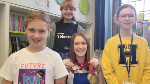 North Yorkshire-based Paralympian and author Danielle Brown and library volunteer Reading Hacks and two children taking part in reading challenge