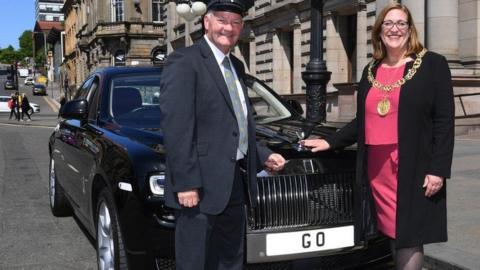 Former Lord Provost and driver standing beside Rolls Royce