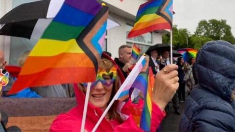 Woman waving rainbow flag