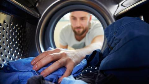 Man looking into washing machine