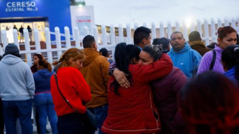 Relatives of inmates react outside the state prison