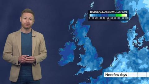 Tomasz Schafernaker stands in front of a UK weather map showing rainfall accumulation totals for the next few days