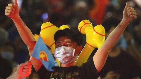 An Workers' Party supporter celebrates a positive return in an early sample count of votes