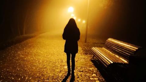 A woman walking alone at night