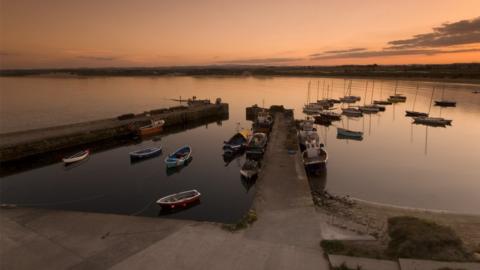 Aerial view of boats in Beadnell harbour at sunset