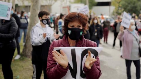 A demonstrator attends a protest against the regional government"s measures to control the spread of the coronavirus disease (COVID-19), at Vallecas neighbourhood in Madrid, Spain, October 4, 2020.