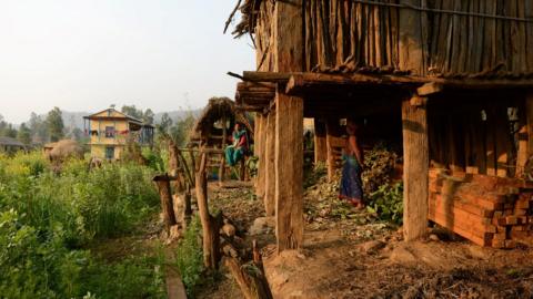 Nepalese women, pictured in February 2017, look at a Chhaupadi hut in Surkhet District