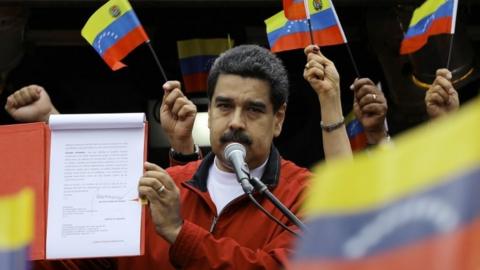 Venezuela's President Nicolas Maduro shows a document with the details of a "constituent assembly" to reform the constitution during a rally at Miraflores Palace in Caracas, Venezuela May 23, 2017.