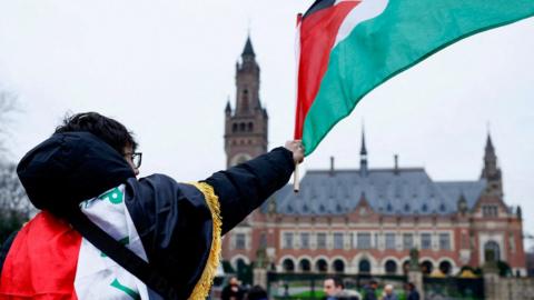 A man waves a Palestinian flag outside the International Court of Justice