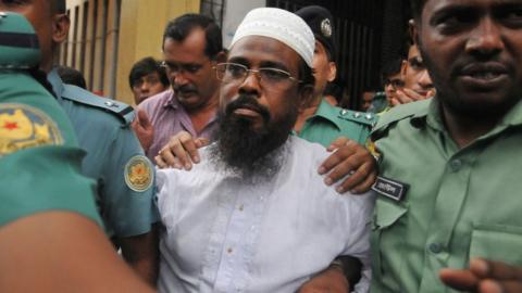 A file photo from 2014 shows Bangladeshi Harkat-ul Jihad al Islami leader Mufti Abdul Hannan flanked by police officers after a court appearance in Dhaka