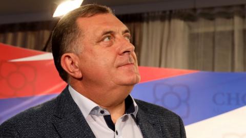 Milorad Dodik is pictured against a background in the national colours