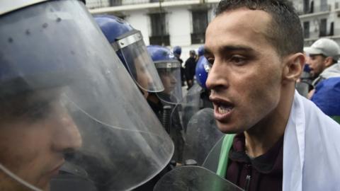 Algeria protester stands-off against man in riot helmet