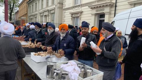 Outside Soho Road Gurdwara being served food