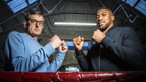 Louis Theroux and Anthony Joshua with their fists up