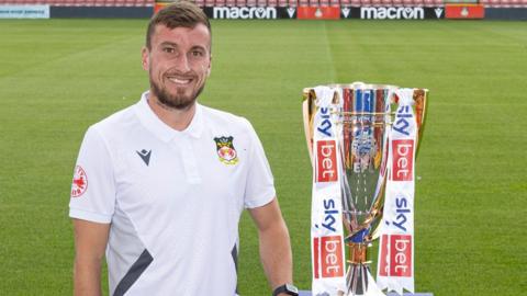 Wrexham's Luke Young poses with the League Two trophy