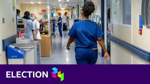 A nurse walks down a corridor in an NHS hospital