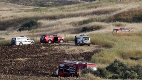 Police and rescue vehicles have been investigating the grassy, hilly area where one of the bodies was found near the village of Orounta in Cyprus