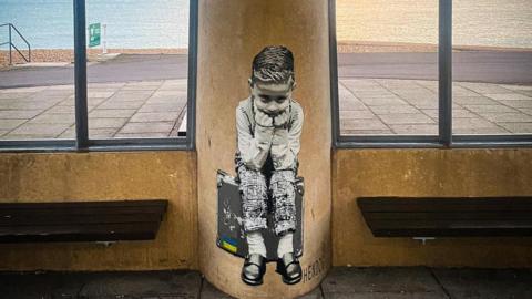 Mural picturing boy sat on his suitcase