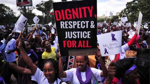 Women hold up placards and shout slogans during a rally against violence to women, on November 17, 2014 in Nairobi.