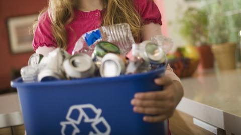 Child holding recycling bin