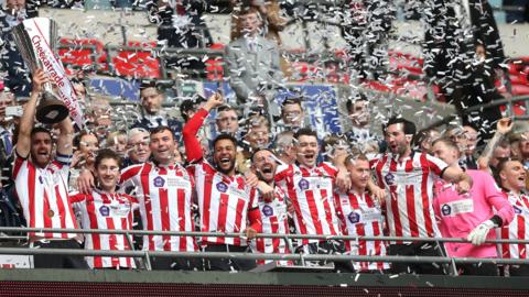 Lincoln City lift the EFL Trophy on the Wembley balcony