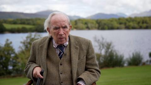 Ian Hamilton sitting next to a Scottish Loch