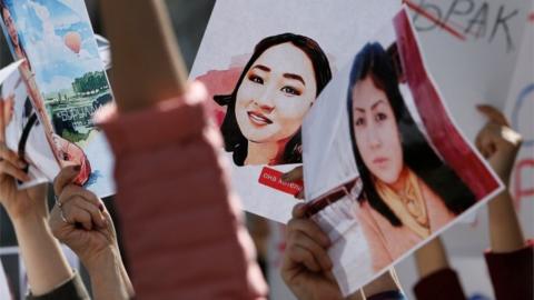 People hold placards during a rally in front of Kyrgyzstan's interior ministry demanding the resignation of its leadership after the murder of Aizada Kanatbekova