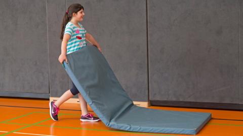 Girl with a PE mat