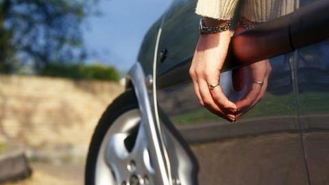 Hand hanging out of window of customised car