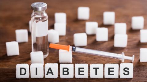 Diabetes with a syringe, insulin and sugar cubes