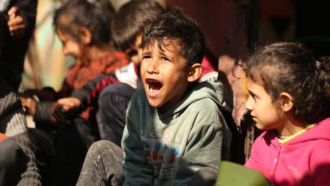 A Palestinian child reacts as Palestinian people survive under difficult conditions at Jabalia Refugee Camp in Gaza on February 26, 2024.