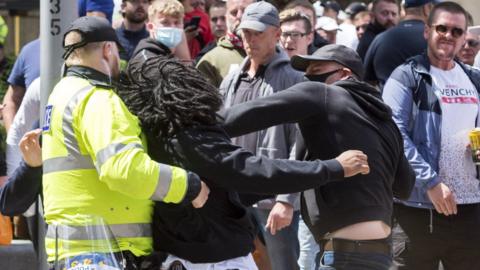 Picture of a man punching another man at the rally at Bristol's cenotaph on Saturday