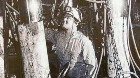 Black and white picture of a miner working in a mine