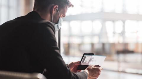 Man looking at phone in airport