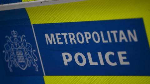 A metropolitan police logo is displayed on a vehicle in London